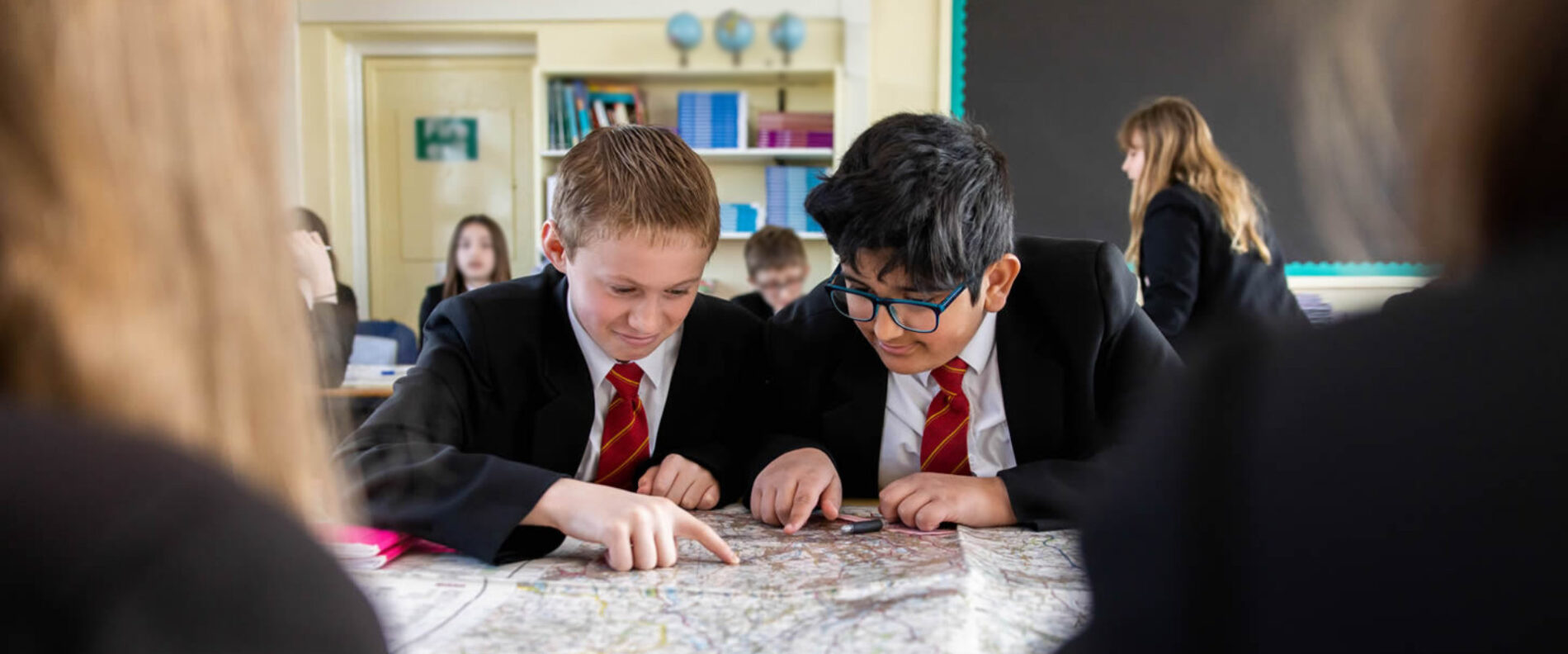 Geography students using a map in lesson